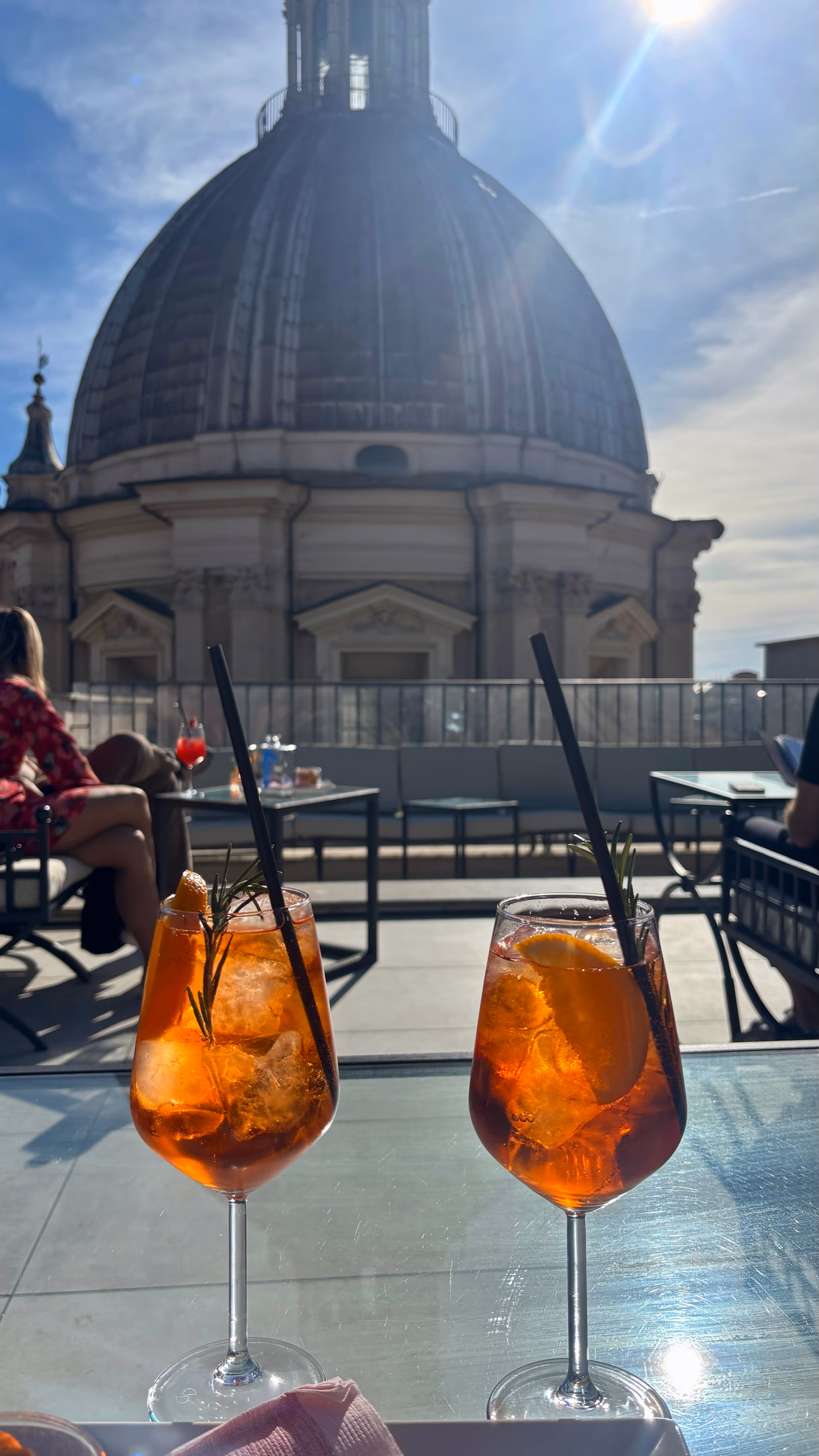 Zwei Aperol auf der Dachterrasse, dahinter die Kuppel der Basilika
